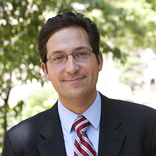 A man wearing glasses and a suit