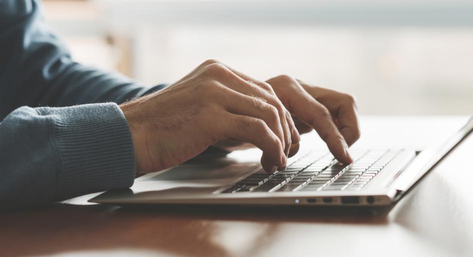 Hands type on a keyboard