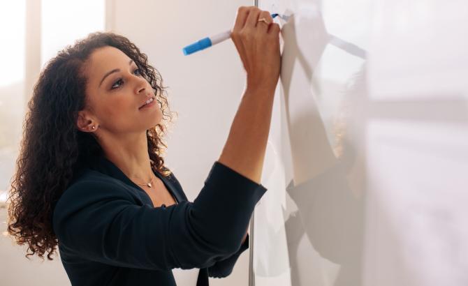 A woman writes on a whiteboard