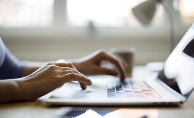 Hands type on a keyboard