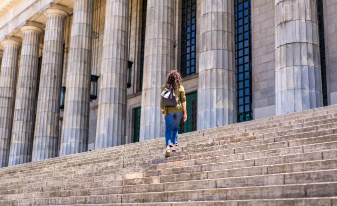 A student walks up courthouse steps