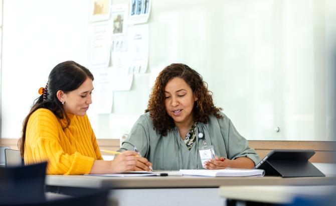 Two women sit together at a table