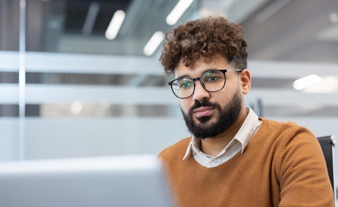 A man types on a laptop