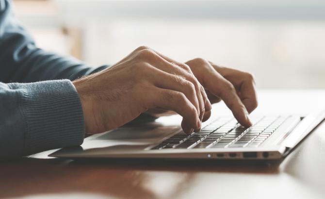 Hands type on a keyboard